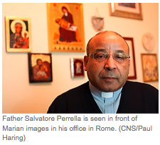 Father Salvatore Perella is seen in front of the Marian iamges in his office in Rome. (CNS/Paul Haring)